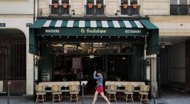 Classic Paris bistro with terrace tables and green awning
