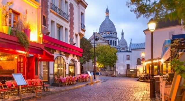 paris-montmartre-sacre-coeur-evening-lights Montmartre’s cobblestone street and Sacré-Cœur at blue hour with café lights in Paris