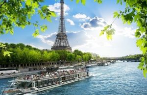 Seine River Cruise Guide (Best Time, Piers, Seats & Prices) Sightseeing boat on the Seine with the Eiffel Tower in the background on a sunny day