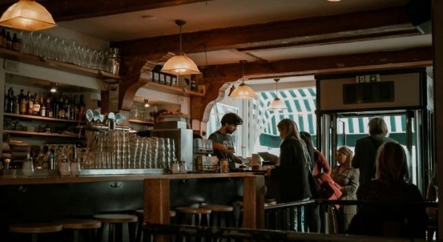 amsterdam-cozy-cafe-interior Cozy Amsterdam café interior with people ordering coffee and warm wooden details