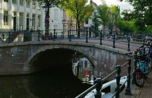 Best Things to Do in Amsterdam: Top Experiences & Hidden Corners Amsterdam canal bridge with bikes at sunset