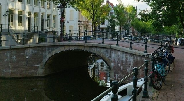 Amsterdam canal bridge with bikes at sunset