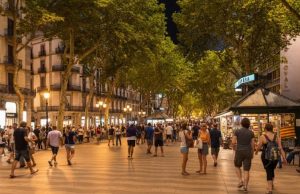 Barcelona at Night: Best Illuminations & Evening Walks (Map + Safety Tips) Evening crowds under plane trees on La Rambla, Barcelona
