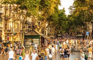 Barcelona Travel Costs & Budget for 2–3 Days (Sample Prices + Money-Saving Tips) Crowds on La Rambla in Barcelona at golden hour, street kiosks and trees lining the boulevard