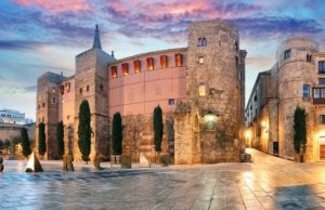 El Born vs. Gothic Quarter: Where to Stay & Hang Out in Barcelona Roman walls and the “Barcino” sculpture at Plaça Nova in Barcelona’s Gothic Quarter at sunset.