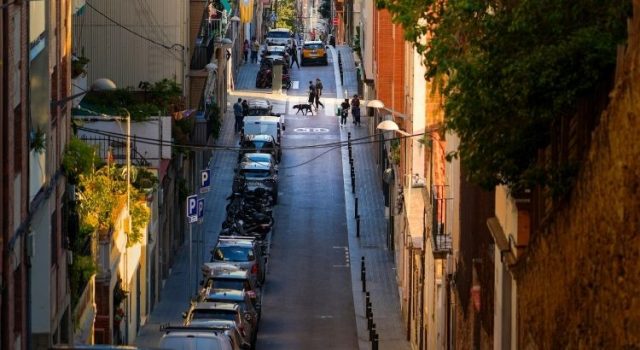 Quiet residential street in Barcelona with locals walking dogs at golden hour