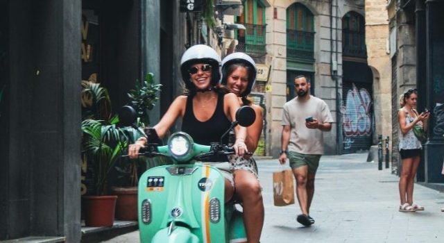 Summer outfits on a scooter in a narrow Barcelona street