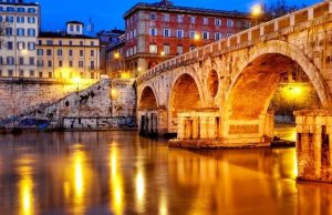 Trastevere Guide: Best Streets, Cafés & Sunset Spots Ponte Sisto at blue hour with warm lights reflecting on the Tiber in Rome