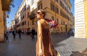 Rome in Spring: Best Time & What to Wear Woman in a spring dress walking along a cobbled street in Rome