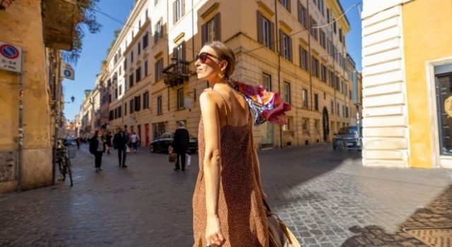Woman in a spring dress walking along a cobbled street in Rome