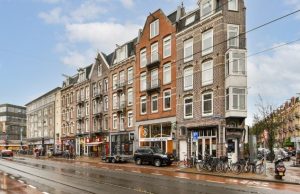 Amsterdam Neighborhoods Guide: Best Areas to Explore (Jordaan, De Pijp, Canal Belt, Nine Streets) Street view of Amsterdam with traditional narrow buildings, bikes and tram line — local neighborhood scene