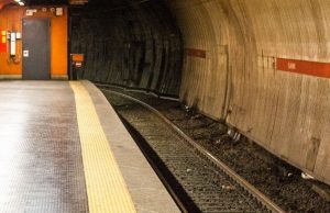 7 Common Mistakes Tourists Make on the Rome Metro (And How to Avoid Them) Empty Rome metro platform showing curved tunnel and yellow safety line near the tracks