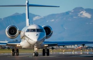 Geneva Airport to City Center: Train, Bus & Free Ticket Hacks (2026) Airplane arriving at Geneva Airport with the Alps in the background, representing transport options from the airport to the city center.