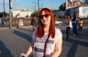 Istanbul Street Food Diaries: The Fish Sandwich (Balık Ekmek) at Galata Bridge (2026) Woman enjoying Istanbul street food near Galata Bridge, famous for balık ekmek (fish sandwich) vendors and Bosphorus views