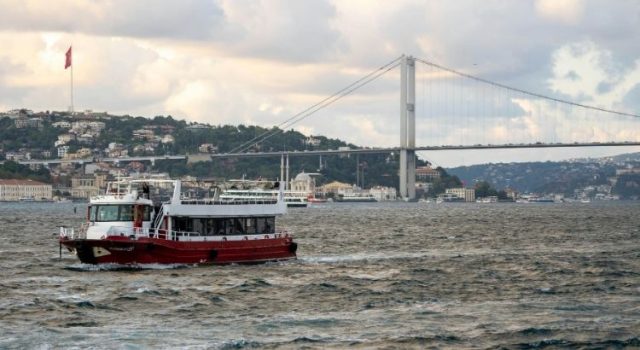 Traditional Istanbul ferry crossing the Bosphorus with Bosphorus Bridge and city skyline in the background