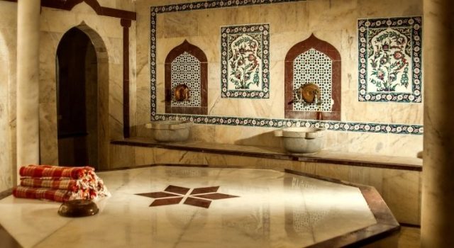 Interior of Kılıç Ali Paşa Hamam showing traditional marble göbek taşı, basins, and Ottoman tile details in Istanbul
