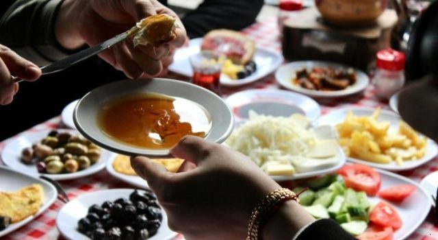 Traditional Turkish breakfast table in Beşiktaş featuring honey, cheese, olives, tea, and fresh vegetables in Istanbul